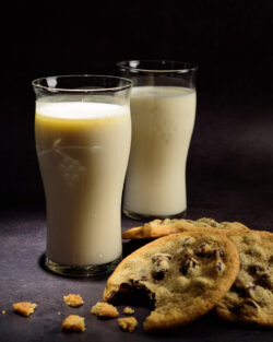 Whole milk with cream on top and chocolate chip cookies