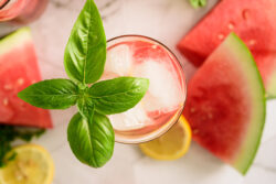 Watermelon Lemonade on ice from above with a basil leaf
