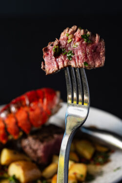 Steak bite on fork above surf and turf